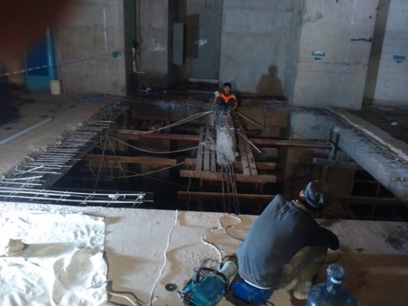 Dua pekerja merakit pembesian dan bekisting kayu pada lubang pelat lantai di proyek Jakarta Aquarium Indonesia
